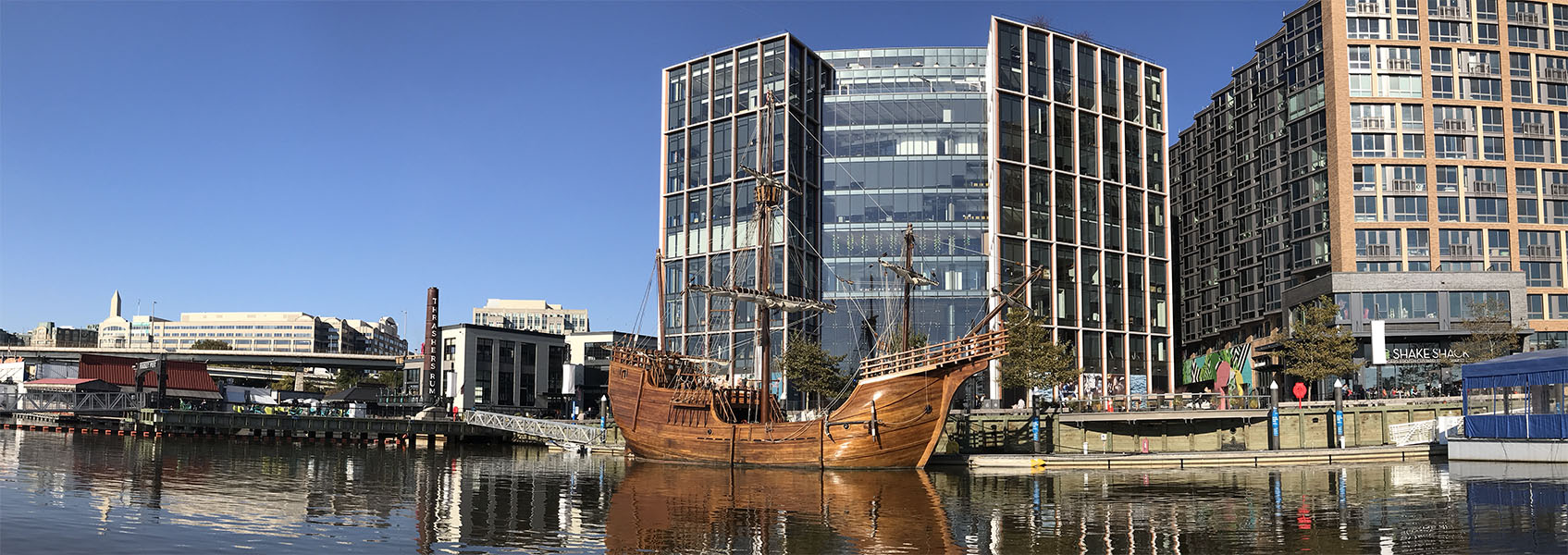 Photo of Replica Santa Maria Sailing Ship Visiting the Washington DC Waterfront with Modern Buildings in Background.
